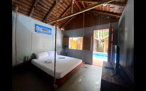 锡基霍尔The Bangka Beach Guesthouse的卧室配有秋千床和窗户。