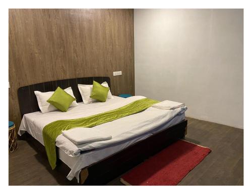 乔斯希马特Auli Eco Nature Resort的一间卧室配有一张带绿床单和枕头的床。