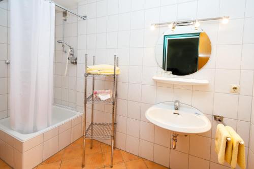 鲁波尔丁Gästehaus beim Schneidersepp的一间带水槽、浴缸和镜子的浴室