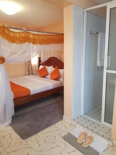 纳库鲁Allamanda Gardens Resort的一间卧室配有一张床,地板上设有凉鞋。
