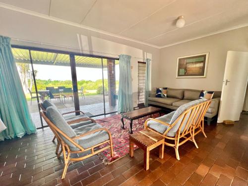 圣卢西亚St Lucia Holiday Cottage的客厅配有沙发、椅子和桌子