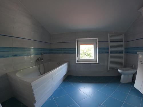 塞扎纳Attic apartment with a terrace的浴室配有白色浴缸和水槽