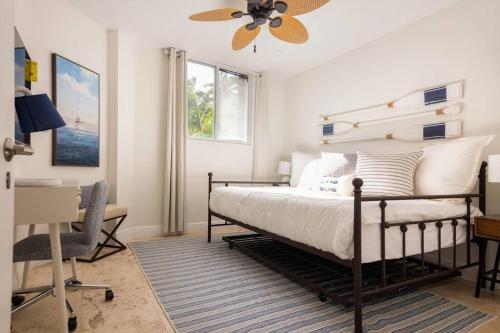 迈阿密KEY BISCAYNE BEACH VACATION #3的一间卧室配有一张带吊扇的床和一张书桌。