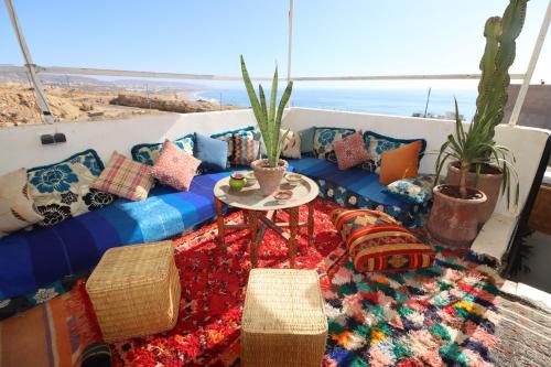 塔哈佐特Welle Surf Morocco的客房设有带枕头的沙发和桌子。