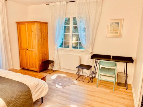 布克Parc de BUC的一间卧室配有一张床、一张书桌和一个窗户。