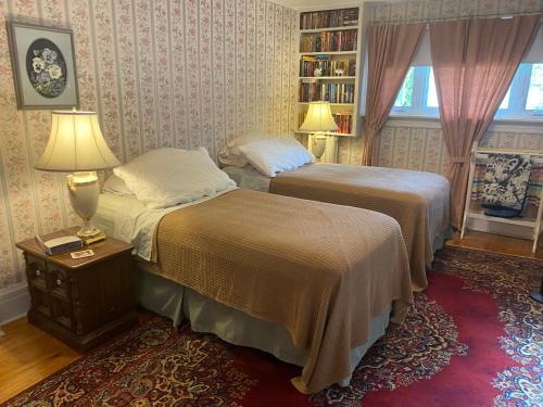 滨湖尼亚加拉Bernard Gray Hall Bed and Breakfast的一间卧室设有两张床和书架