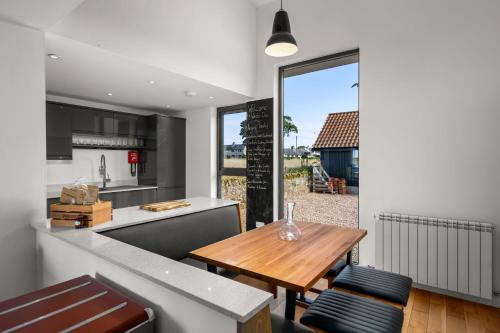 阿布罗斯Wester Den的厨房以及带木桌的用餐室。