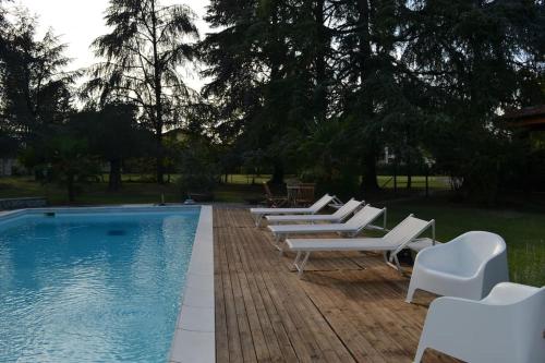 里韦尔加罗Apartment in Villa La Carruba的游泳池旁的一排躺椅