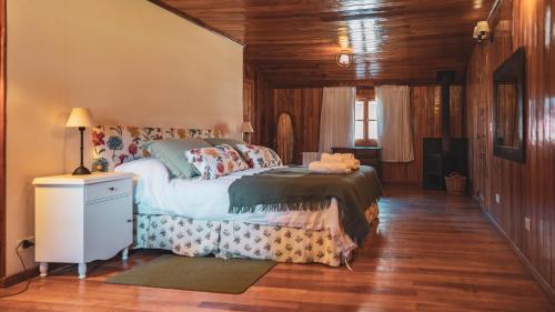 圣马丁德洛斯Hostería Villarino的铺有木地板的客房内设有一间卧室和一张床。