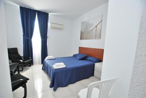 滨海比拉萨尔Hotel Tres Leones的一间卧室配有蓝色的床和椅子