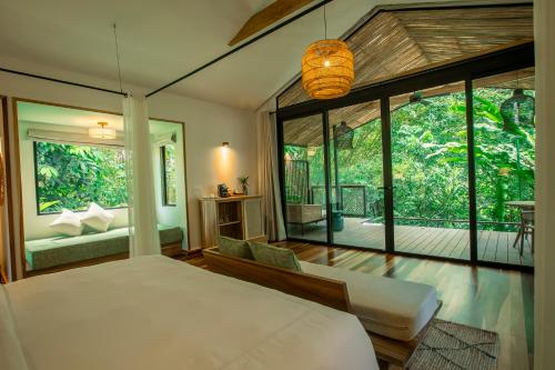 福尔图纳Nayara Gardens的一间卧室设有一张床和一个大窗户