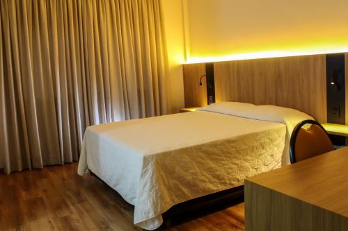 VideiraHotel das Videiras的酒店客房设有两张床和一张桌子。
