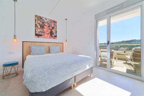 La MairenaLuxury Penthouse at La Cala Golf的一间卧室设有一张床和一个大窗户