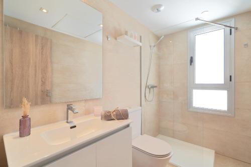 La MairenaLuxury Penthouse at La Cala Golf的一间带水槽和卫生间的浴室以及窗户。