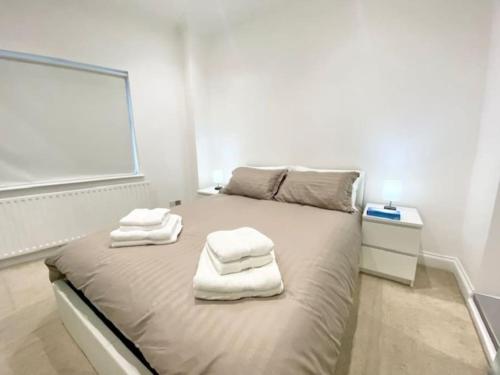 伦敦2 Bedroom Flat in Whitechapel!的一间卧室配有带毛巾的床