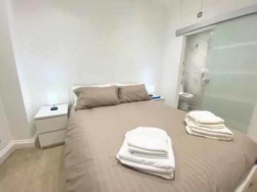 伦敦2 Bedroom Flat in Whitechapel!的一间卧室配有一张带白色毛巾的床