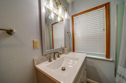 伊利Cozy Erie Vacation Rental with Patio and Seasonal Pool的一间带水槽和镜子的浴室以及窗户。