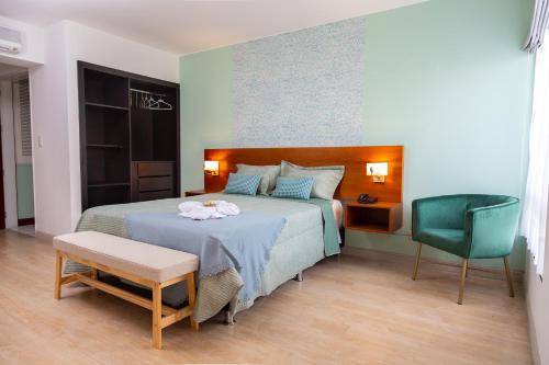 利马Hotel San Blas的一间卧室配有一张床和一把绿色椅子