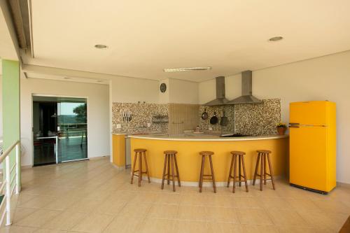阿蒂巴亚Natureza na cidade的厨房设有黄色柜台和酒吧凳