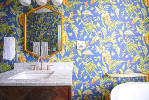 萨凡纳Carriage House on Chatham Sq的浴室设有水槽和蓝色及金色壁纸。