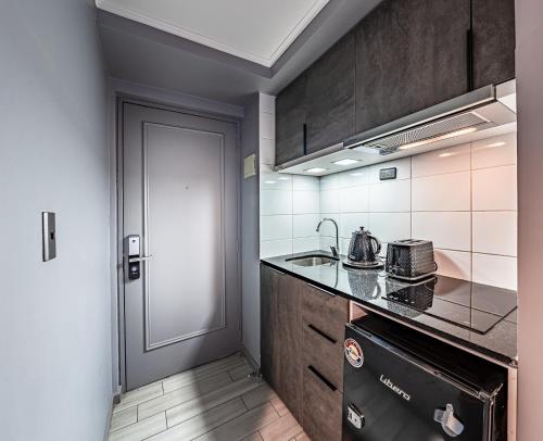 圣地亚哥Encomenderos Design Tech Comfort & Location的厨房配有炉灶、水槽和门