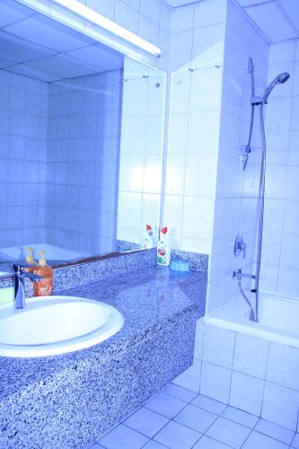 迪拜Dreams Hostel的一间带水槽、淋浴和镜子的浴室