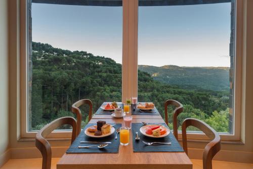 格拉玛多Laghetto Resort Golden Oficial的窗户前的一张木桌,上面放着食物板