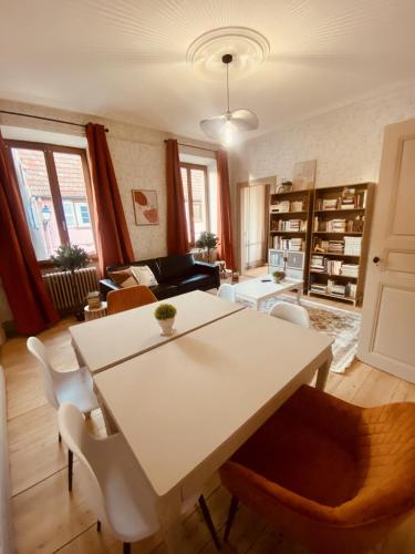 拉佩蒂特皮耶尔LA MARIEFACTURE - Comme un Livre Ouvert的客厅配有白色的桌子和椅子