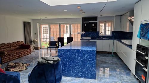 达格纳姆Studio Flat with kitchen and toilet included的厨房以及带蓝色台面的起居室。