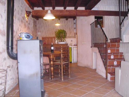 Cabañas de PolendosCasa Rural con Jacuzzi Taberna del Tio Pedro的客房内的厨房配有桌子和冰箱