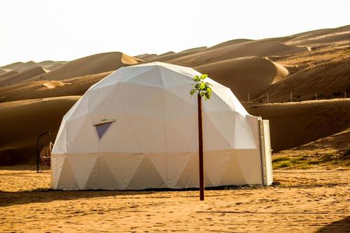 Al WāşilGolden Desert Camp Al Wasil的沙漠中的一个白色帐篷