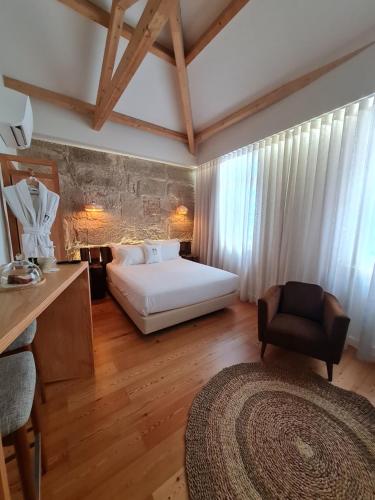 波尔图Porta Nobre - Exclusive Living Hotel的一间卧室,卧室内配有一张床和一把椅子