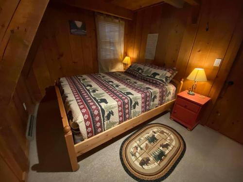 艾恩伍德U.P Norse A-frame close to Powderhorn Ski Resort的一间卧室配有一张床和一张带台灯的桌子