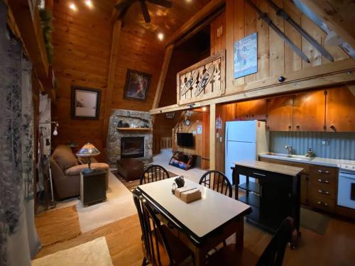 艾恩伍德U.P Norse A-frame close to Powderhorn Ski Resort的厨房以及带桌子和壁炉的客厅。