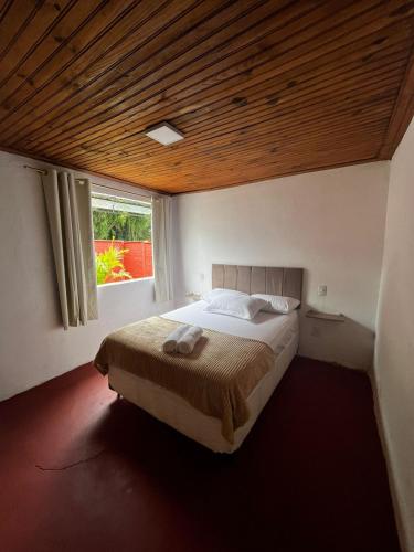 蒂拉登特斯Casa do Chafariz Tiradentes的一间卧室设有一张带木制天花板的大床