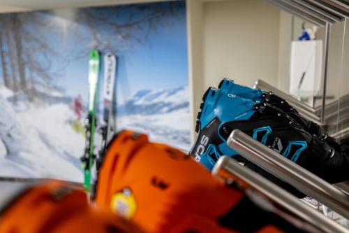 利维尼奥嘎马拉维利亚酒店的一组滑雪板和手套坐在画旁边