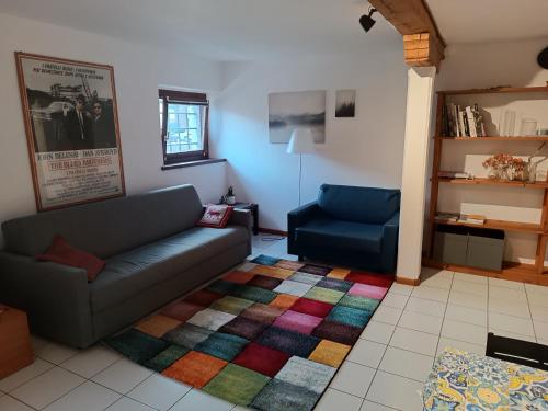 阿奎莱亚Amnis的客厅配有沙发和色彩缤纷的地毯