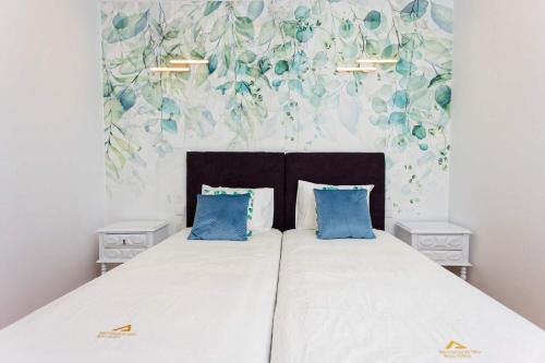 曼瓜尔迪Quinta Refúgios do Rio Dão的一间卧室配有一张带蓝色枕头的大床