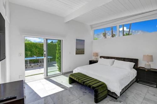 棕榈泉Palm Springs Luxury Home With a POOL, Next to Downtown & Airport的一间卧室设有一张床和一个大窗户