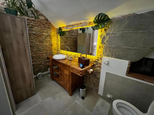 比森齐奥营casatorre medioevale的一间带木制水槽和石墙的浴室