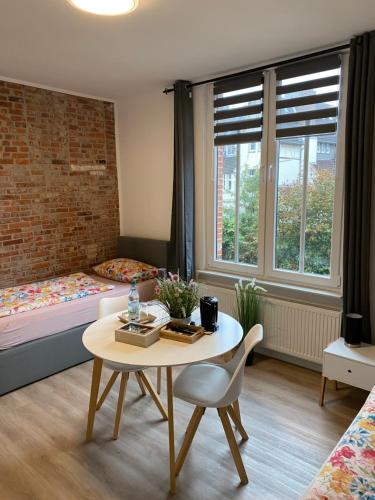 埃姆登Appartementhaus EMDEN的小房间设有桌子和床