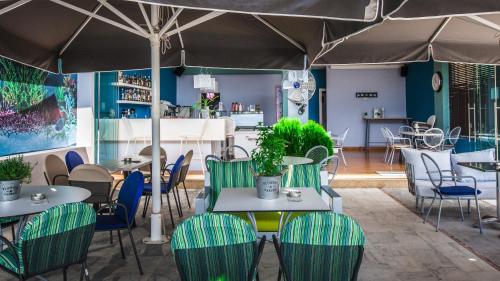 维瓦里Hotel Apanema的一间带桌椅和遮阳伞的餐厅