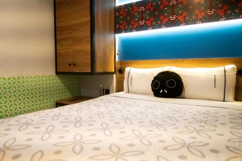 墨西哥城Barrio Downtown Mexico City Hostel的一间设有一张带头骨枕头的床的房间