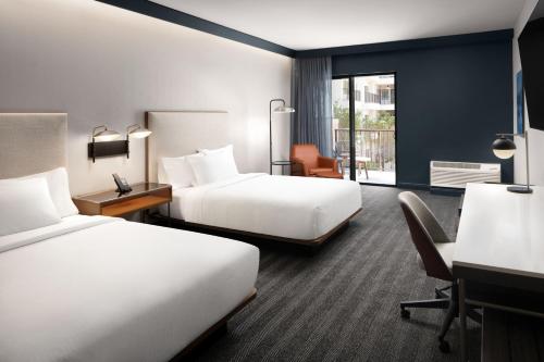 盖恩斯维尔Courtyard by Marriott Gainesville GA的酒店客房设有两张床和一个阳台。