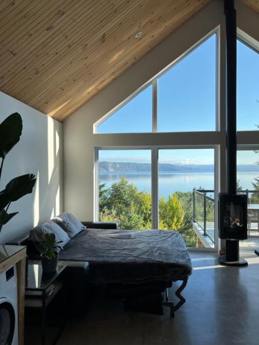 萨格奈Magical Loft : Breathtaking View & Cozy Fireplace的一间卧室设有一张床和一个大窗户