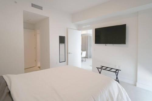迈阿密Brand New Apartment in Brickell with parking的白色卧室配有床和平面电视
