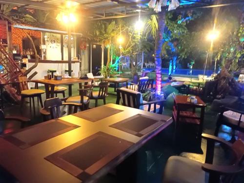 Ban Bo Sai KlangOASIS Phuket Airport的晚上,餐厅设有桌椅
