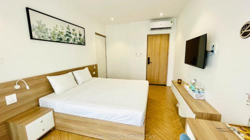 Cam LâmThe Track Homestay的卧室配有白色的床和电视。