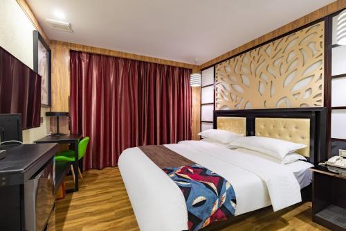 广州广州市荔湾区雀洲酒店的酒店客房配有一张床、一张书桌和一台电脑