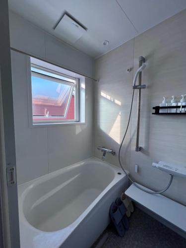 KimobetsuTHE LOBS, RUSUTSU的白色的浴室设有浴缸和窗户。